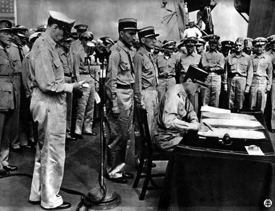 A bord du "Missouri" (bâteau de guerre américain), le général Leclerc signe l'acte de capitulation japonaise au nom de la France. A gauche, devant les micros, le général Mac Arthur.